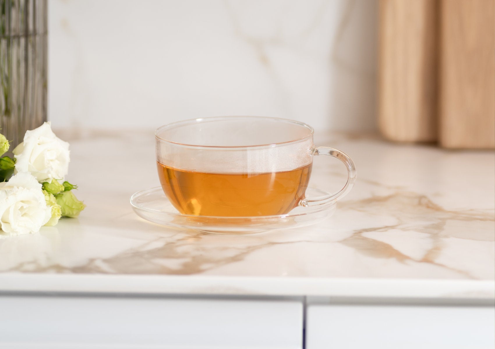 Gelbgrüner Eistee im Glas mit Eiswürfeln und Zitronenscheibe