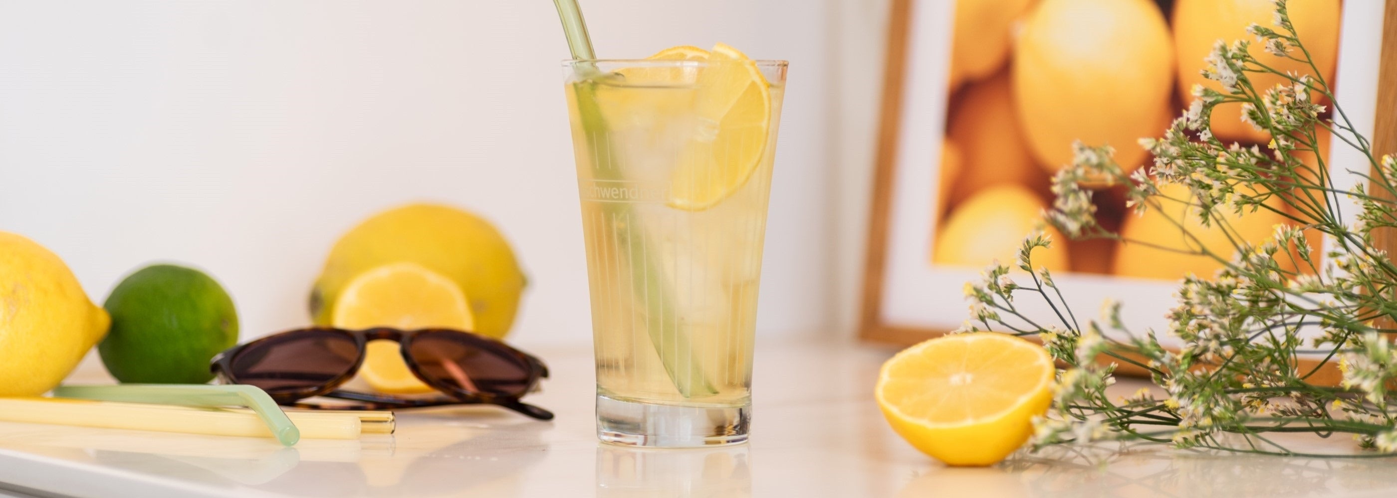 Gelbgrüner Eistee im Glas mit Eiswürfeln und Zitronenscheibe